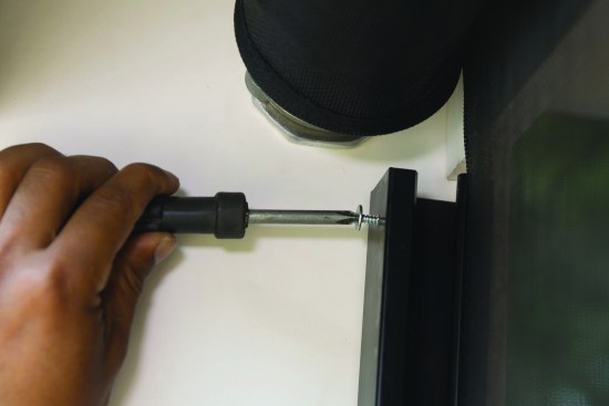 Set screws at the top of the aluminum tracks prevent the roller assemblies from jumping the rails as the screens retract.