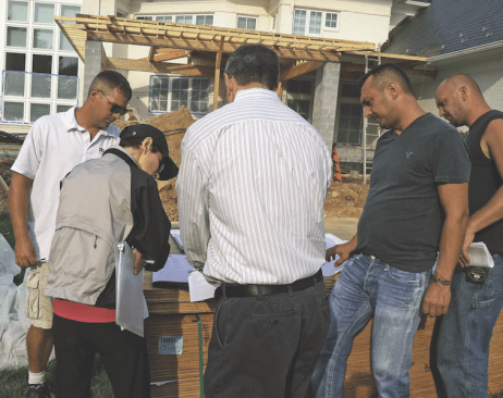 Frequent ad-hoc meetings between project managers, production managers, and trade contractors to iron out critical details help to keep jobs moving and on schedule. Here, metal roof details are being discussed with the roofing contractor.