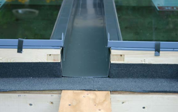 The channel gets cut flush with the heads and is then overlapped 6 inches by the combination head-sill flashing.