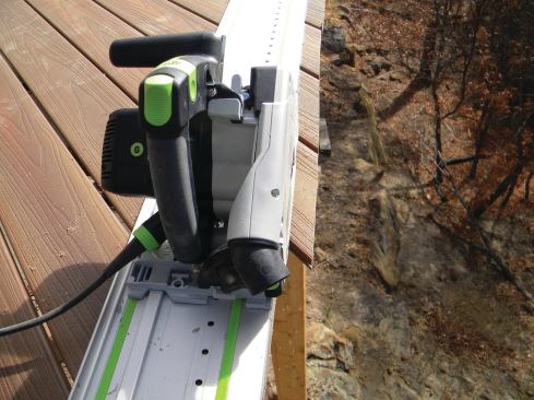 Deck boards are installed long and then cut in place along a straight line so the trim will lie flat once it’s attached. A track saw, like the Festool TS55REQ shown, is ideal for the job.