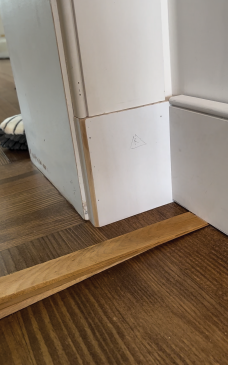 With the baseboard shimmed level, measure how much it needs to drop (1/8 inch here) to match the plinth block.