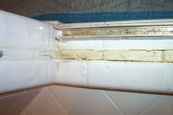 Door tracks channel water right where the grout is most likely to crack.