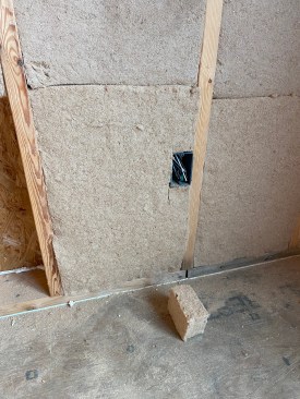The batt with the cut-out is fit around the box, leaving behind only a box-sized piece of scrap.