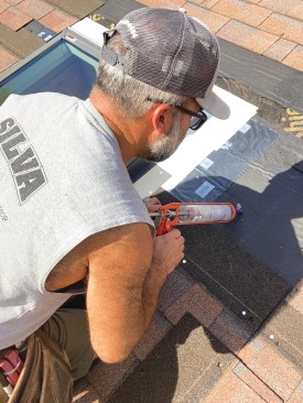 A couple of roofing nails, located according to the manufacturer’s installation instructions so that they will be covered by step flashing, hold the first section of curb flashing in place. When reinstalling shingles, I first fill any holes in the roofing underlayment with sealant and avoid driving nails through the old holes in the shingles, filling them with sealant instead.