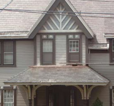 The main roof of this turn-of-the-century Victorian still has most of its original slates, while the asphalt shingles installed on the building’s lower porch roof in mid-century are at the end of their service life.