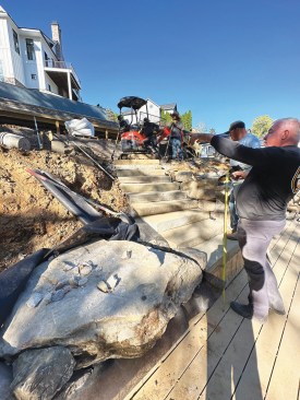 Here, the crew is installing the stone steps that connect the lowest tier to the dock system.