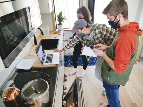 From right, students Ryan Tasto, Jacob Apple and Heather Walker conduct tests in the 2021 Solar Decathlon house entry for the University of Colorado Boulder being built in Fraser, CO. (Photo by Casey A. Cass/University of Colorado)