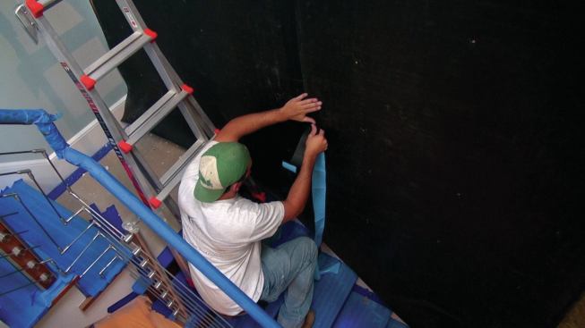 All the seams on the membrane covering a stairwell party wall are taped off. Any holes would reduce the barrier's effectiveness.