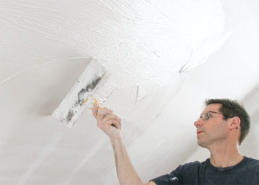He removes excess compound with a wide knife before it has a chance to dry, then lightly sands the entire surface before priming.