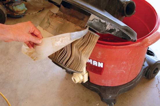 Riveting a plastic flap between the vac’s hose inlet and the filter helps keep the filter free from muck during wet cleanup. For dry vacuuming, the flap protects the paper filter from incoming jagged debris.