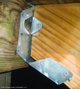 At a cost of a few dollars each for the connectors and recommended fasteners, the most cost-effective way to hang a stringer is with metal hardware. But this one - a Simpson Strong-Tie LSU26Z - has been installed incorrectly, since the stringer isn't fully bearing on the connector seat. Another red flag: Drywall screws instead of approved connector fasteners have been used to fasten the connector to the framing.