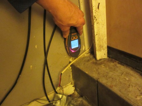 In addition, the company inspects all adjoining homes, in this case (above) using a moisture meter to monitor moisture levels in a party wall.