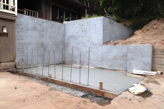 Considerable sitework was required to improve drainage prior to pouring new deck footings, retaining walls, and the slab that would support the planters and staircase.