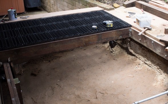 Silca Systems plastic grates are light and easy to cut, and they attach to the deck framing with four screws. Here the framing has been dropped slightly so that the pavers can extend seamlessly over the adjacent retaining wall and concrete slab.