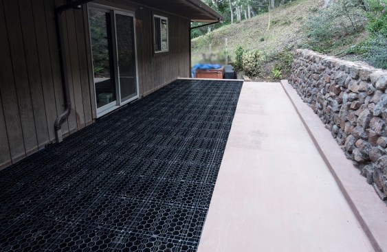 Prior to installing the stone pavers, the author applied an isolation membrane to the slab. The pavers over the slab were set in thinset mortar, and simply glued to the grating with construction adhesive.
