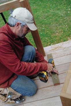 When both runs of the kitchen were built, I matched them up in the corner and shimmed them to level. I screwed cleats to the deck boards, then screwed the cabinets to the cleats. The cabinets were also screwed to the deck posts.