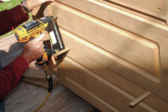 After fitting the fronts, I routed them with the same panel profile used on the cabinet ends. I set the drawer fronts in place and shot a couple of 18-gauge brads through the fronts to hold them in place ...