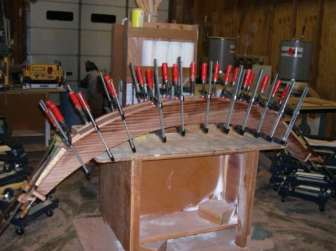 I then dressed the side and front faces of the posts and beams with 4/4 sapele, again routing the edges flush with the core before applying the adjacent overlapping pieces. I ran these pieces long on the tongued ends and short on the forked ends to provide an additional structural overlap at the corner joint.