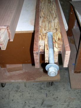 The plan called for bolting the finished brackets through solid posts in the first-floor wall framing. To avoid bungs or other weather-vulnerable surface marring, I encapsulated the 1-by-12-inch galvanized machine bolts within the bracket verticals. During bracket assembly, I set one bolt at the top in a pocket cut into the saddle joint ...
