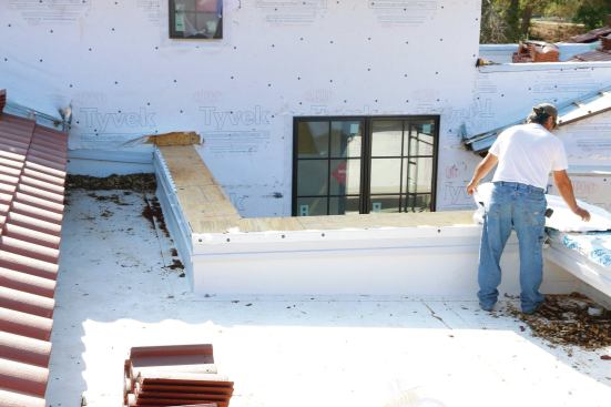 The carpenters framed the parapet cap with a slope draining to the inside.
