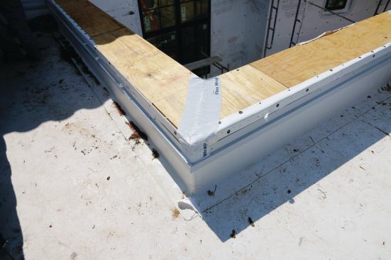 Tyvek FlexWrap is applied wherever the parapet cap takes a turn, to ensure a watertight seal where the straight flashing will need to be cut.