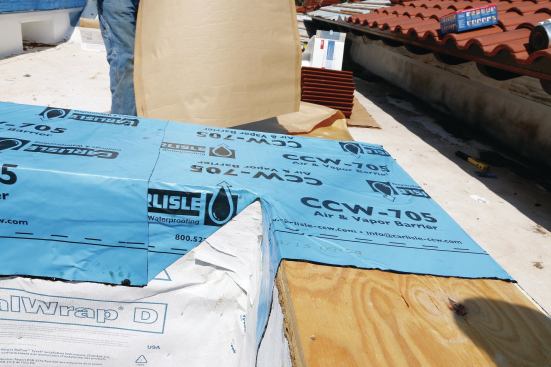 The sheet membrane applied over the parapet caps doesn't stretch and must be carefully folded around corners.