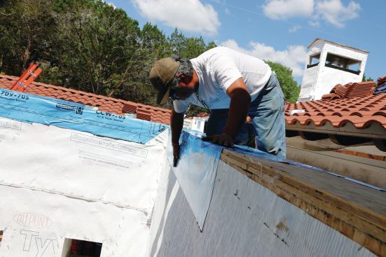 Flashing needs to wrap over the entire cap in one piece and hang down at least 4 to 6 inches over the housewrap to provide a good shingle effect.