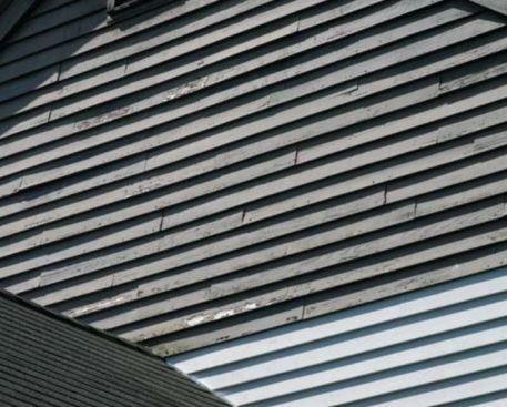 Moisture migrating from inside the home through the backs of the clapboards also attacks the adhesion of the paint or stain on the exterior wood surfaces, causing premature loss of the coating. The new preprimed clapboards at the lower right of this gable-end wall, installed as part of a window replacement, will perform much better in service.