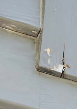 Water has entered unprimed end grain and caused the piece to check. If the carpenters had primed all cut ends, and if the original painters had prepped the wood and applied a fresh field primer, the onset of failure could have been postponed for years.