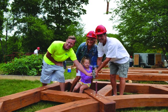Family and friends are always invited to help assemble the company’s timber frames. Here, the pavilion’s purpleheart “giving peg” is being hammered into place.
