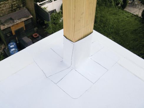The orange-handled tool next to the post is a pointed probe that’s run carefully along welded seams to pinpoint any missed areas. The boot’s overlapping split side — which allows it to be wrapped around a continuous column — is welded closed. The open top of the finished boot will be covered with flexible flashing.