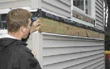 Figure 3. Houses aren't always straight, so the author checks the ledger with a string. Variations greater than 1/4 inch mean that the joists will have to be custom cut.