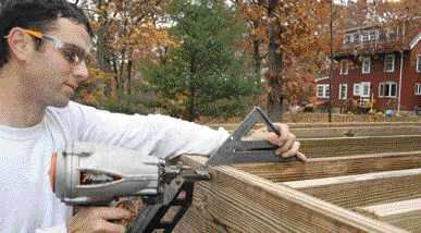 Figure 10. Before being attached to the beam, the joists are leveled with and nailed to the rim joist. Shims are added between the joists and the beam if needed; then the pre-installed hurricane ties are nailed to the joists.