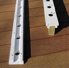 Figure 2. The jig is made from PVC sheet such as AZEK, preferred over wood for its stability. Holes drilled on 4 1/2-inch centers hold the baluster connectors as they're screwed home.