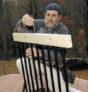 Figure 4. To firm up the assembly, the author drills a through hole at one of the central baluster connectors and runs a length of threaded rod between the upper and lower rails.