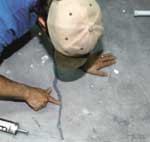 Figure 1. A special check valve is used to prevent the sub-slab ventilation system from sucking indoor air through the floor drain. It opens for drainage when weighted down by accumulated water, but when the drain is dry, a spring-loaded ball provides a seal that maintains negative pressure beneath the slab (top). Once the valve has been cemented in place (center), any visible cracks in the slab or foundation walls are repaired with a durable sealant (bottom).