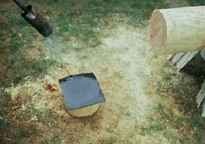 Figure 5. A propane-fired torch is used to heat torch-down roof membrane. Once heated, the membrane will be adhered to the bottom of the log post and trimmed to fit exactly. This membrane helps prevent water from wicking up the log and causing rot.