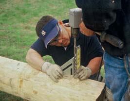 Figure 6. A torpedo level and a layout square are used to guide the drilling of holes for the bolts that will secure the log to the anchor.