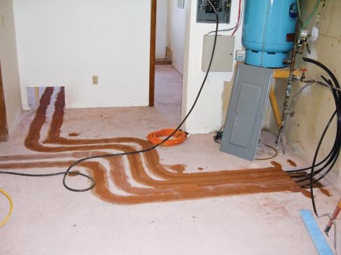 The author cut 1 1/4-inch-deep grooves in the slab to accept radiant piping, and then grouted them flush with the floor. 