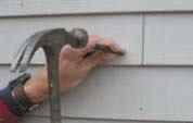 Figure 5. Driving nails through the siding with a nail set leaves large holes. Reinstallation is still possible - just use nails with larger heads in the same holes.