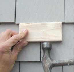 Figure 9. To blind-nail a replacement shingle, hold it slightly below its intended location and nail it just below the butt line of the course above. A few taps with a block and a hammer drive the shingle into place, bending the nails mostly out of sight at the same time.