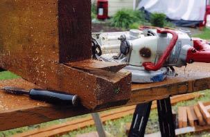 Figure 4. Two circular saws — one right-tilting and one left-tilting — are used to notch the back posts to fit the angled rim joist. A chisel cleans out the waste.