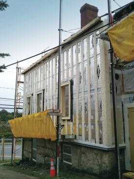 Then the walls were wrapped with foil-faced foam and the seams taped. Vertical strapping was screwed through the foam and into the framing to attach the siding and trim. Extra stock was later added around window and door openings for nailers.