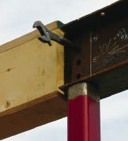 The drift-punch handle of a rigger’s wrench aligns beams for bolting.

