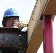 A welded bolt flange stiffens the beam web beneath a second-floor column location and also supports a right-angle beam.