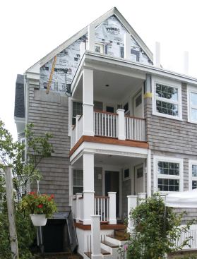 The finished porch was trimmed out with PVC post and column wraps, moldings, and balusters, combined with mahogany stair treads, fascia trim, and railings.