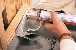 Rubber sealant is applied to the pan membrane and the curb framing.