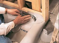 The pan membrane is folded tight against the framing and stapled in place.