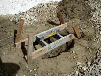 Figure 1. The form for the top of the footing is made from 1x4s fastened together at a slight angle. Four stakes support it and keep it level above the footing hole.