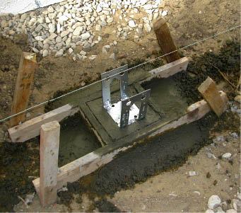 Figure 2. A string aligns the placement of a post base in wet concrete. Once the concrete has set, it will be easy to remove the form.